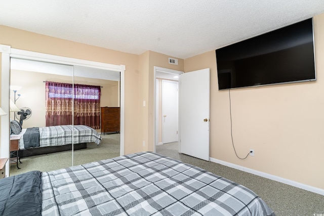 carpeted bedroom with a textured ceiling and a closet