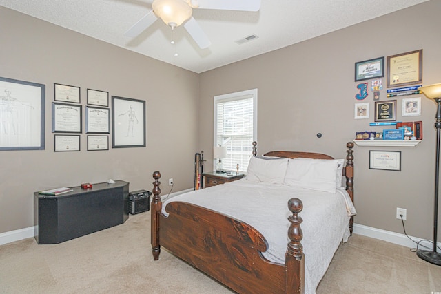 carpeted bedroom featuring ceiling fan and a textured ceiling