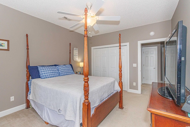 carpeted bedroom featuring ceiling fan, a closet, and a textured ceiling