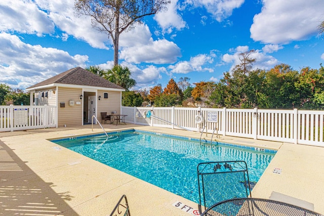 view of pool with an outbuilding and a patio