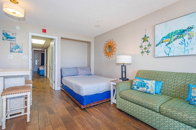 bedroom with a textured ceiling and dark wood-type flooring