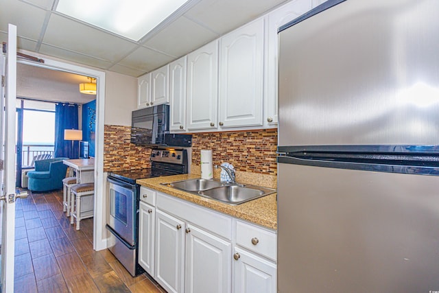 kitchen with sink, stainless steel appliances, dark hardwood / wood-style floors, a paneled ceiling, and white cabinets