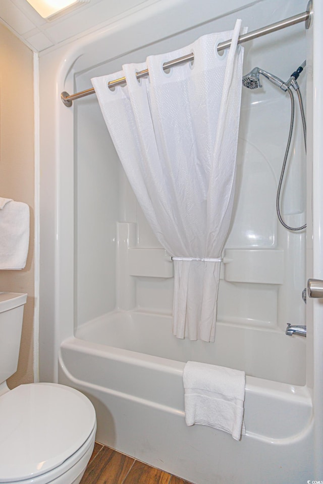 bathroom featuring hardwood / wood-style floors, bathtub / shower combination, and toilet