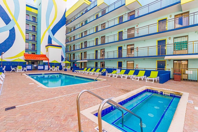 view of swimming pool with a patio and a hot tub