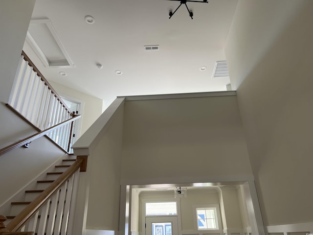 staircase with recessed lighting, visible vents, and a high ceiling