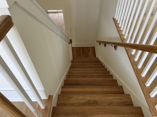 staircase with wood finished floors and baseboards