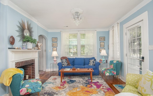 interior space with hardwood / wood-style flooring, ornamental molding, a fireplace, and a chandelier