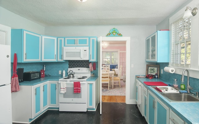 kitchen with a textured ceiling, white appliances, sink, and blue cabinets