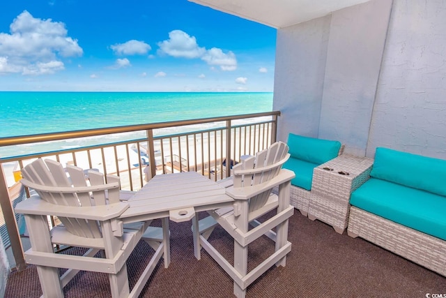 balcony with a beach view, outdoor lounge area, and a water view