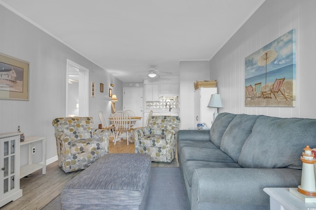 living room with hardwood / wood-style flooring, ceiling fan, and crown molding