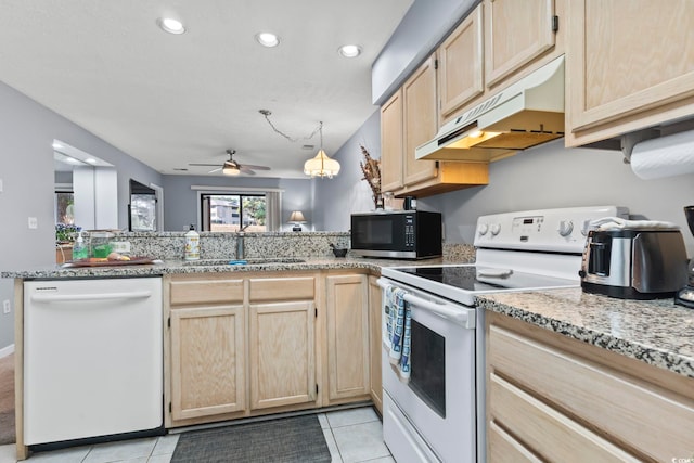 kitchen with kitchen peninsula, sink, light tile patterned floors, and white appliances