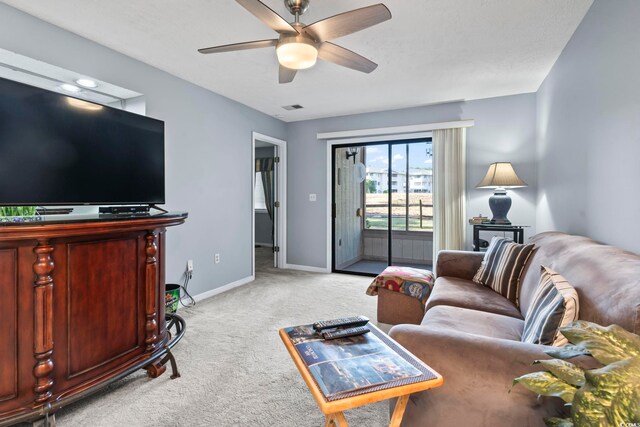 living room with ceiling fan and light colored carpet