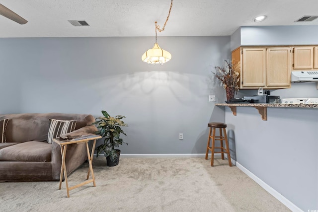 kitchen featuring a breakfast bar, hanging light fixtures, ventilation hood, light colored carpet, and light brown cabinetry