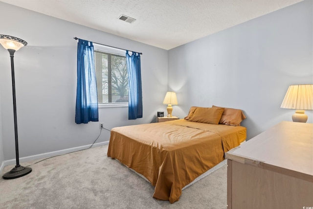 bedroom featuring light carpet and a textured ceiling