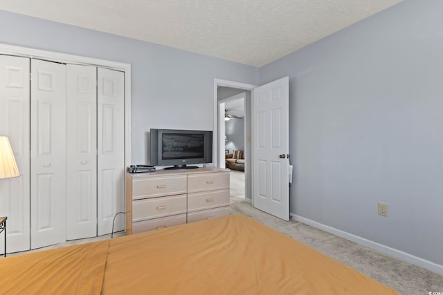 unfurnished bedroom with light colored carpet, a textured ceiling, and a closet