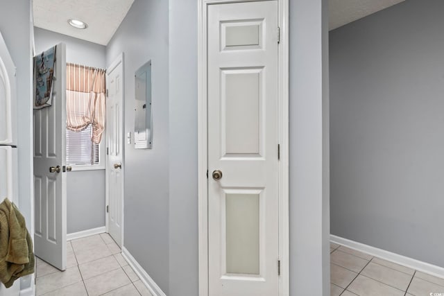 hall with light tile patterned floors and a textured ceiling