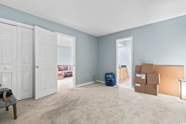 bedroom featuring ensuite bathroom, a closet, and light colored carpet