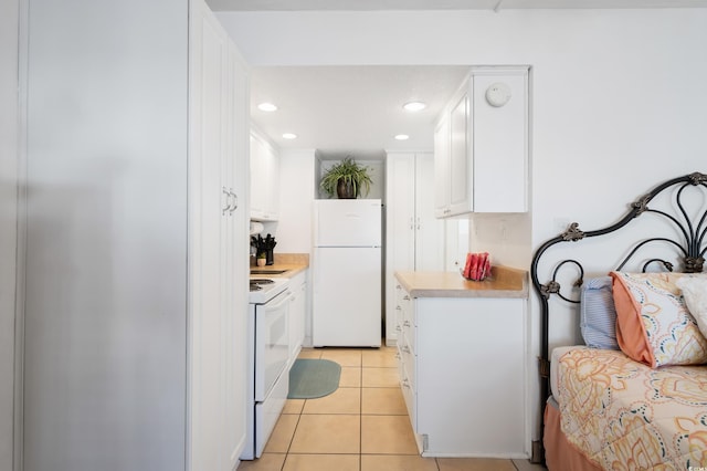 kitchen featuring light tile patterned floors, white cabinets, and white appliances