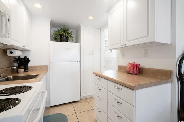 kitchen featuring a textured ceiling, white appliances, white cabinetry, and sink