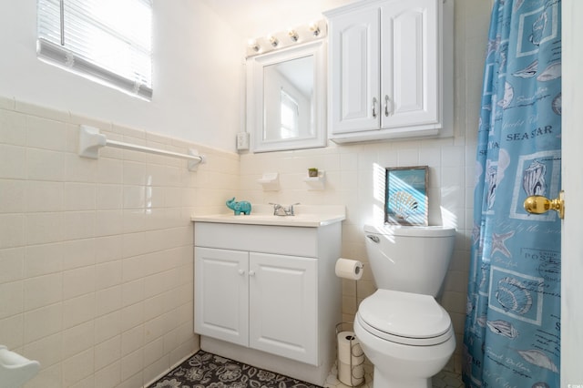 bathroom featuring curtained shower, vanity, tile walls, and toilet