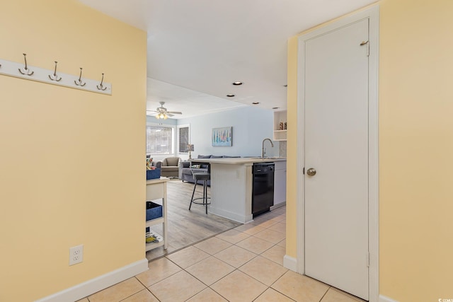 kitchen featuring dishwasher, a kitchen breakfast bar, sink, light hardwood / wood-style flooring, and ceiling fan