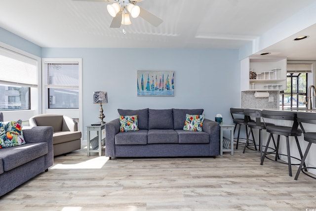 living room with light hardwood / wood-style flooring and ceiling fan