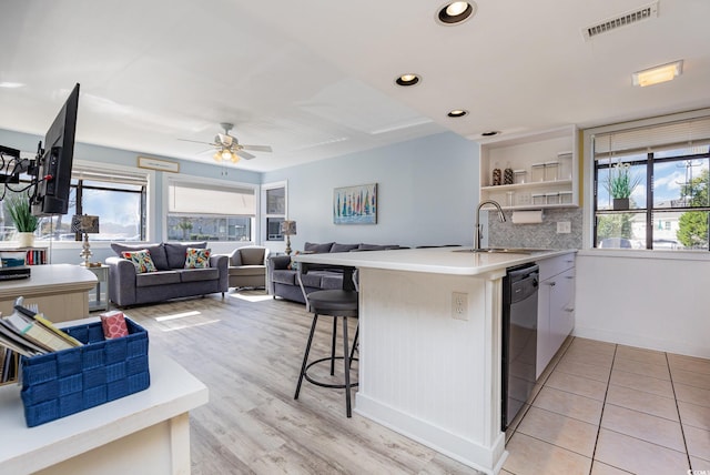 kitchen with kitchen peninsula, a breakfast bar, plenty of natural light, and sink