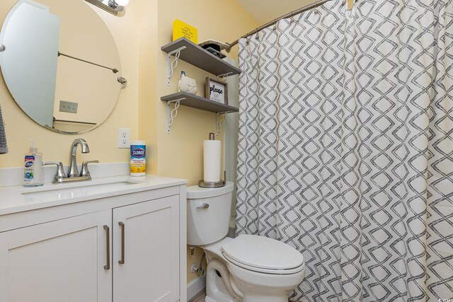 bathroom featuring a shower with shower curtain, vanity, and toilet