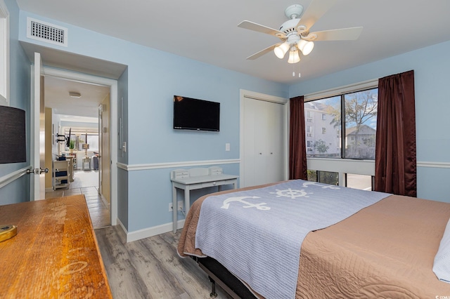 bedroom with ceiling fan, light wood-type flooring, and a closet