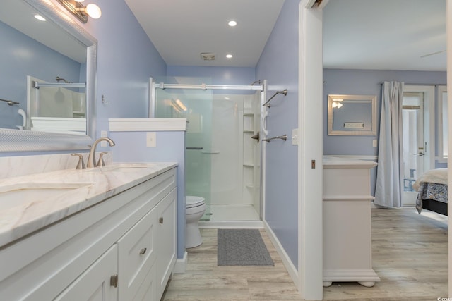 bathroom with vanity, hardwood / wood-style floors, walk in shower, and toilet