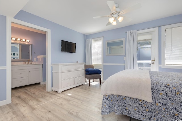 bedroom with sink, ensuite bath, light hardwood / wood-style floors, and ceiling fan