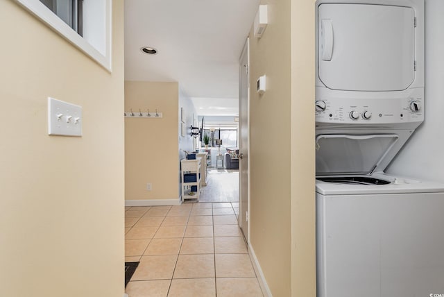 laundry room featuring stacked washer / dryer and light tile patterned floors