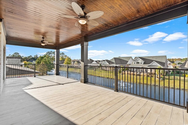 wooden terrace with ceiling fan and a water view