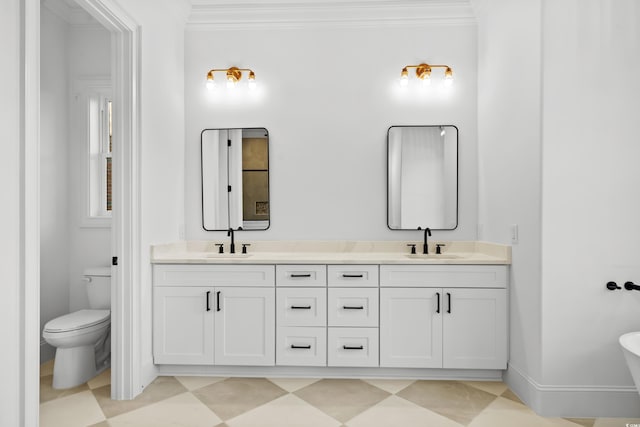 bathroom featuring ornamental molding, vanity, and toilet