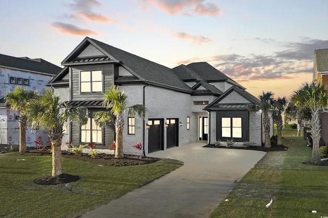 view of front of house featuring a garage and a lawn