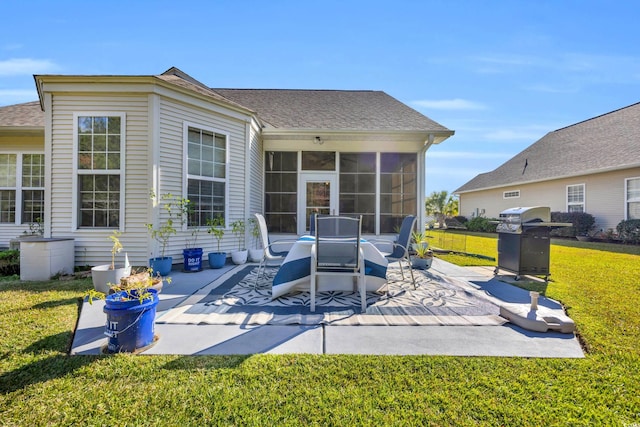 back of property with a sunroom, a patio area, and a yard