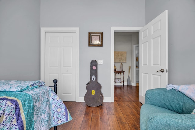 bedroom with dark hardwood / wood-style flooring and a closet