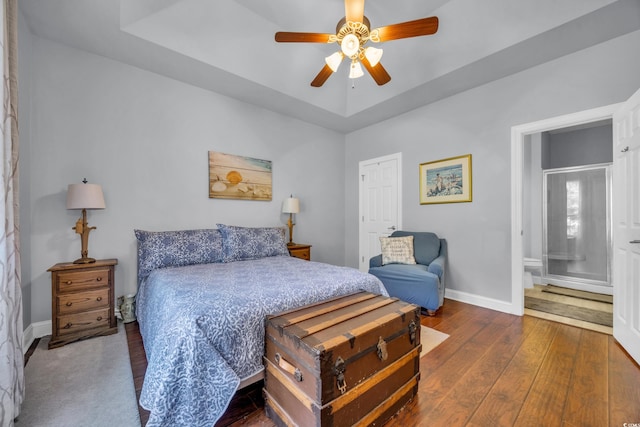 bedroom with a raised ceiling, ceiling fan, and dark hardwood / wood-style flooring