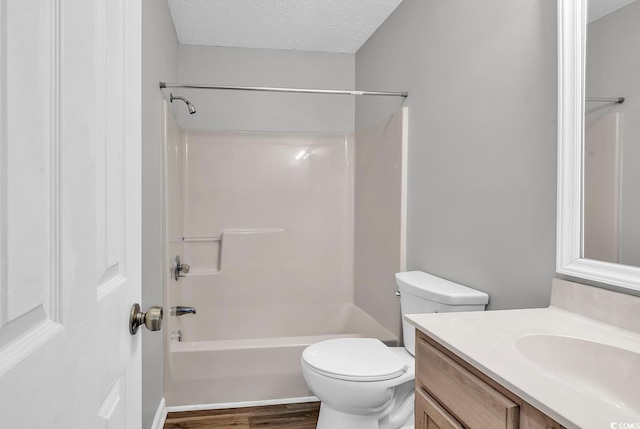 full bathroom with hardwood / wood-style floors, vanity, toilet, a textured ceiling, and shower / bath combination