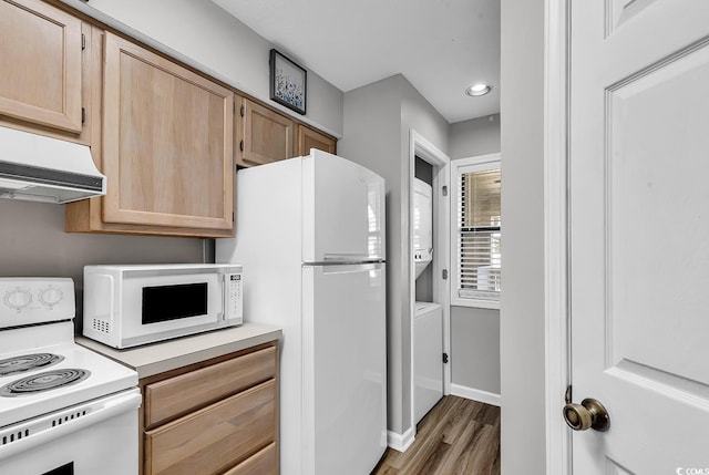 kitchen with light brown cabinetry, dark hardwood / wood-style floors, and white appliances