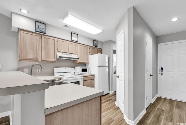 kitchen featuring sink, light hardwood / wood-style flooring, kitchen peninsula, white appliances, and light brown cabinetry