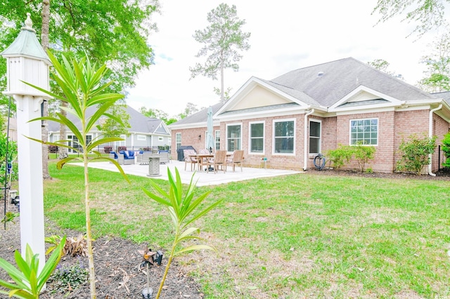 rear view of property featuring a lawn and a patio area