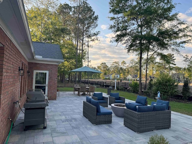 patio terrace at dusk featuring a grill and an outdoor hangout area