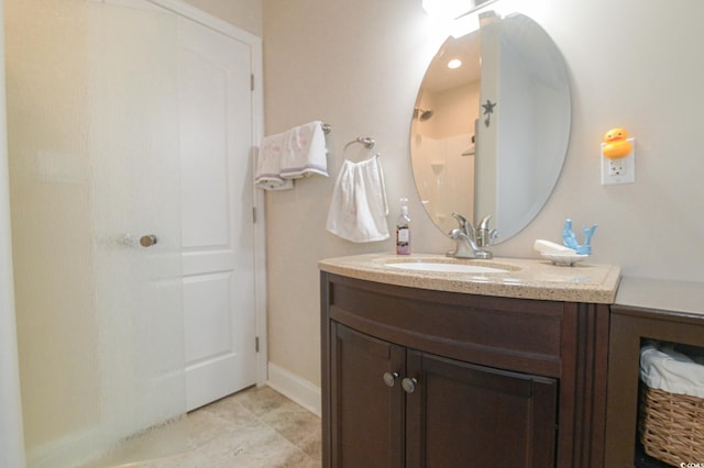 bathroom featuring tile patterned flooring, vanity, and walk in shower