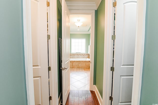 hall with wood-type flooring and ornamental molding