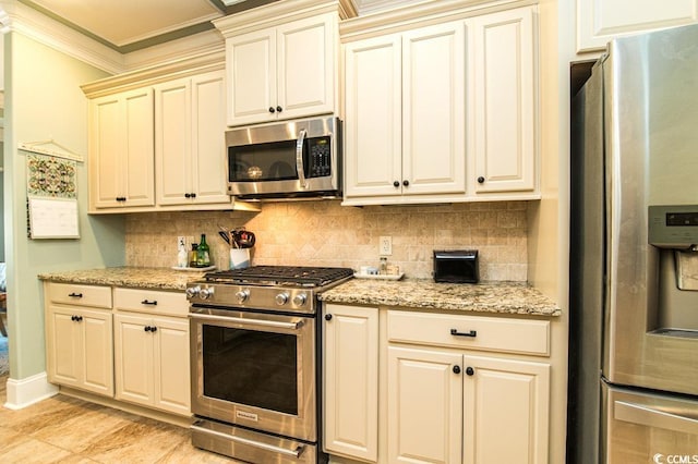 kitchen with light stone countertops, stainless steel appliances, tasteful backsplash, crown molding, and cream cabinets