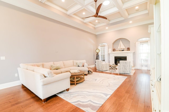 living room featuring hardwood / wood-style flooring, beam ceiling, crown molding, and coffered ceiling