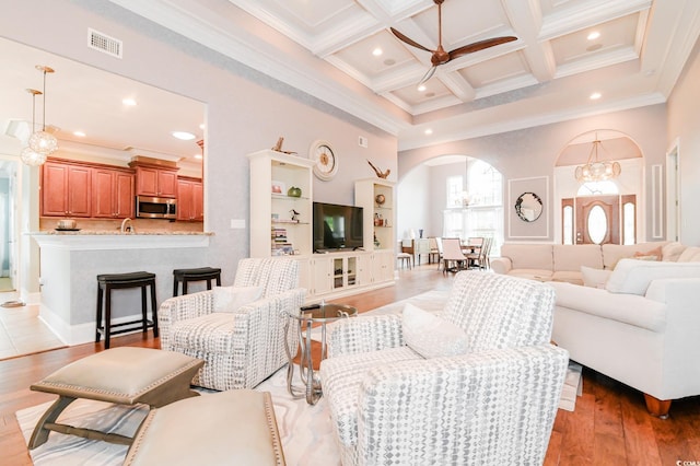 living room featuring crown molding, light hardwood / wood-style flooring, beamed ceiling, and coffered ceiling