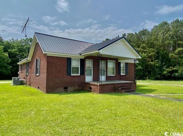 view of front of property with central AC unit and a front yard