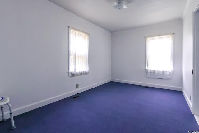 spare room with dark carpet